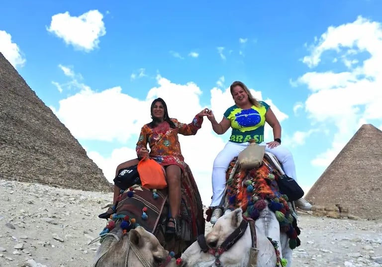 duas turistasa do brasil visitando as piramides e fazendo um passeio de camelo em torno das piramides com HADI GUIA DE EGITO 