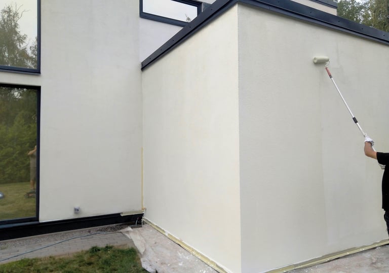 Un technicien expert de chez Oxoclean applique une protection hydrofuge sur une façade d'une maison