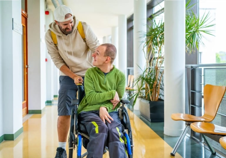 NDIS support worker assisting a man in a wheelchair in a bright, modern hallway