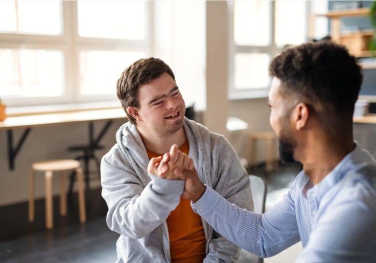 NDIS participant smiling and sharing a friendly moment with a support worker