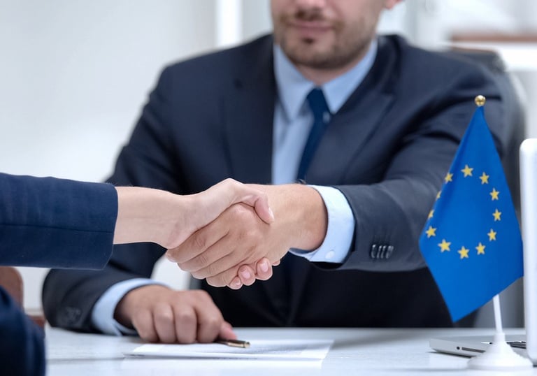 a man and woman shaking hands in front of a laptop
