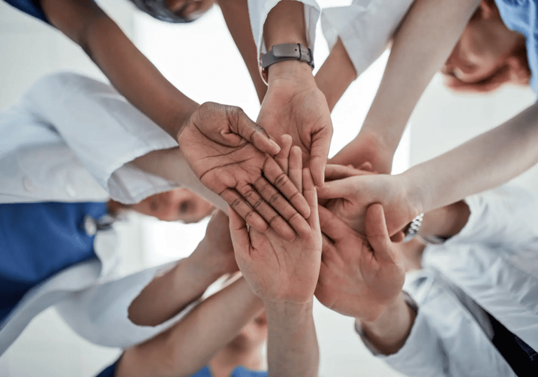 a group of people holding hands together in a circle