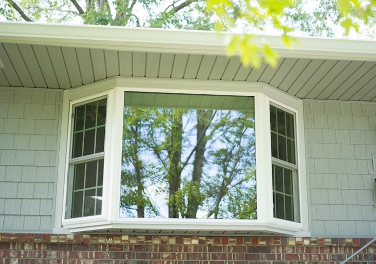 a bay and bow window that extends past the outside wall of the front of the house