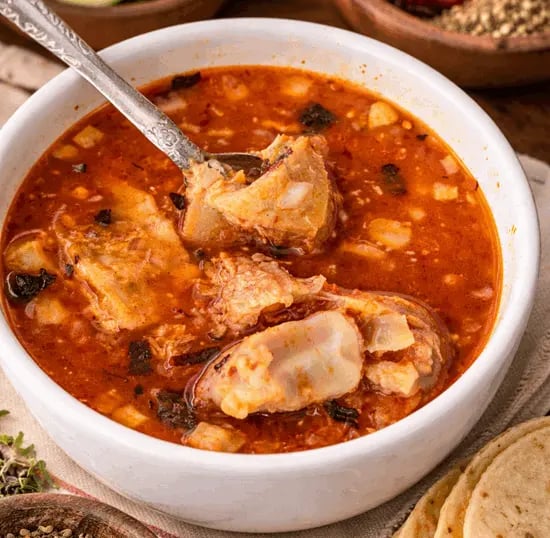 Menudo de res gourmet en caldo rojo con limones y tortillas en Querétaro.
