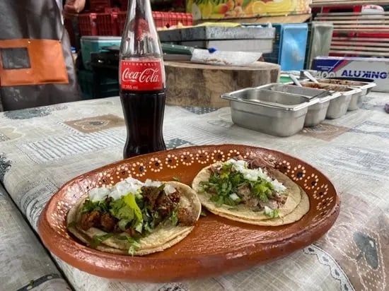 Tacos de barbacoa tradicional con cilantro y cebolla en plato artesanal en Querétaro.