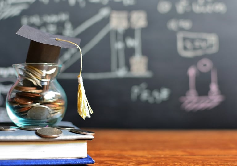 Jar of coins and books on desk with chalkboard background