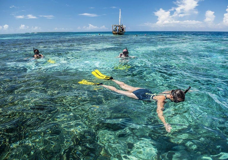 Someone snokelling in Mnemba Island, clear blue water