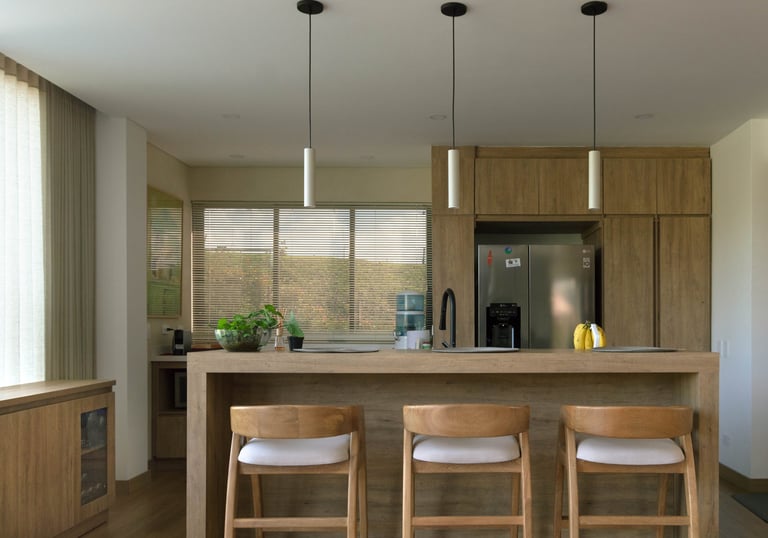 Cocina moderna remodelada en madera clara con isla central, mostrando resultado de proyecto de remod