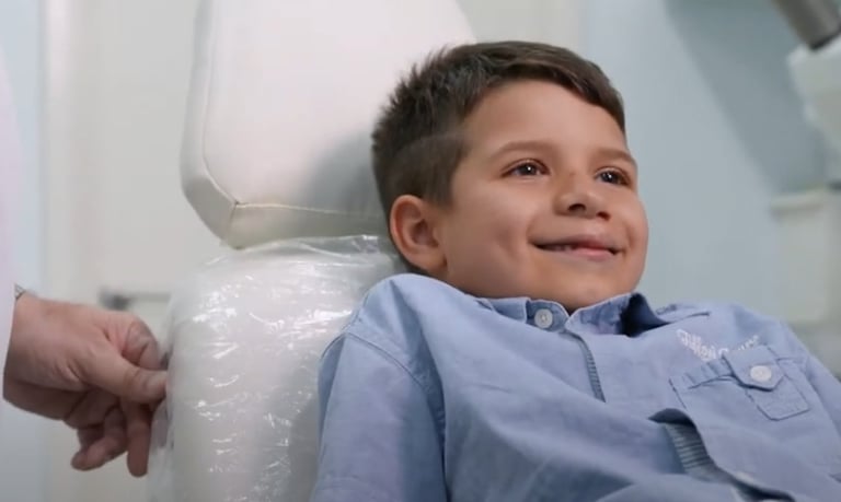 a young boy sitting in a chair in a hospital