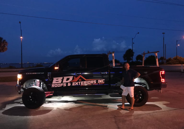 a man standing next to a truck with a truck in the background