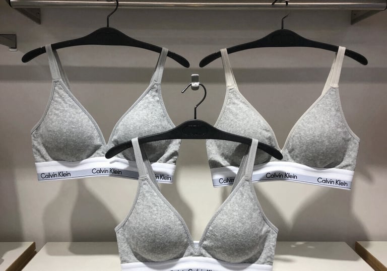 An elegant collection of popular branded cosmetics with sleek packaging on a marble countertop.