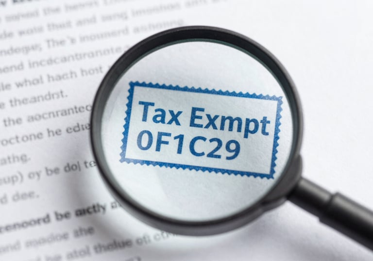 A magnifying glass focusing on a 'Tax Exempt' stamp on a document, illustrating clarity and professional oversight in #B6DDE5 and #0F1C2E.