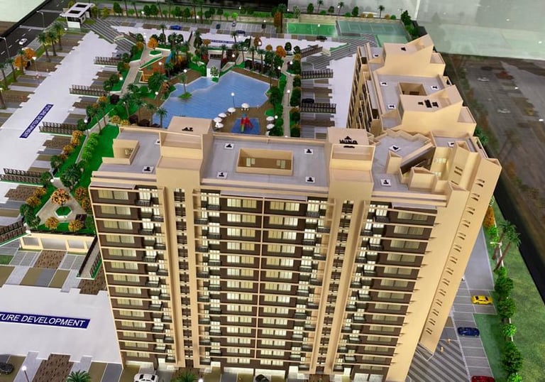 Architectural scale model of a modern high-rise residential complex with a swimming pool and landscape amenities.