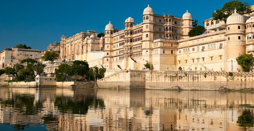 The majestic City Palace Udaipur reflecting in the calm waters of Lake Pichola in Rajasthan, India.