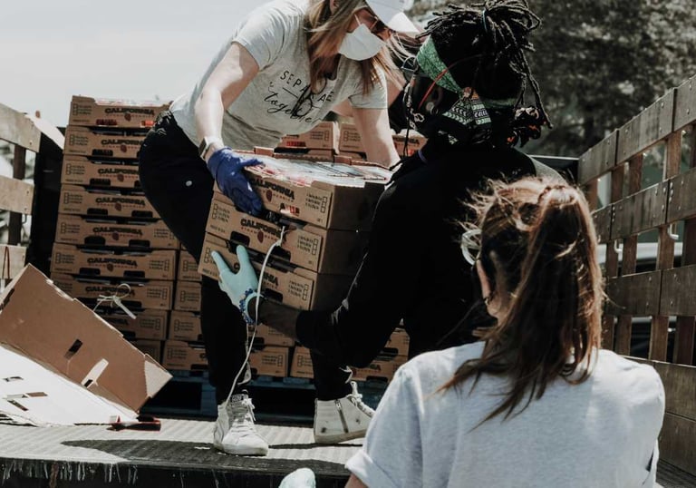 voluntarios ayudando a distribuir mercancia que acaba de llegar al banco de alimentos
