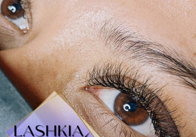 Primer plano de los ojos de una mujer con extensiones de pestañas negras, largas y densas realizadas