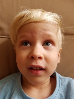 a young boy with blonde hair and a blue shirt