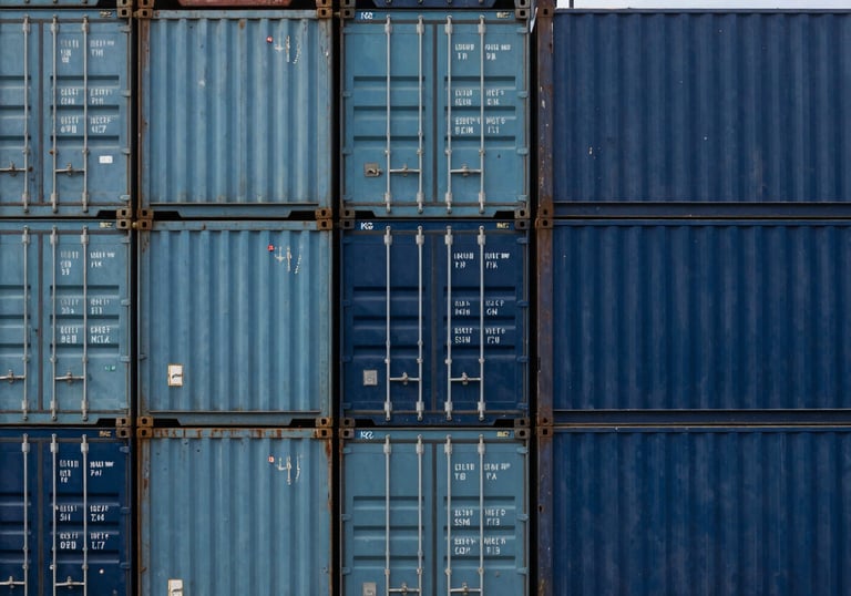 A top-down view of a stack of clean, modern shipping containers in shades of steel blue and navy blue.
