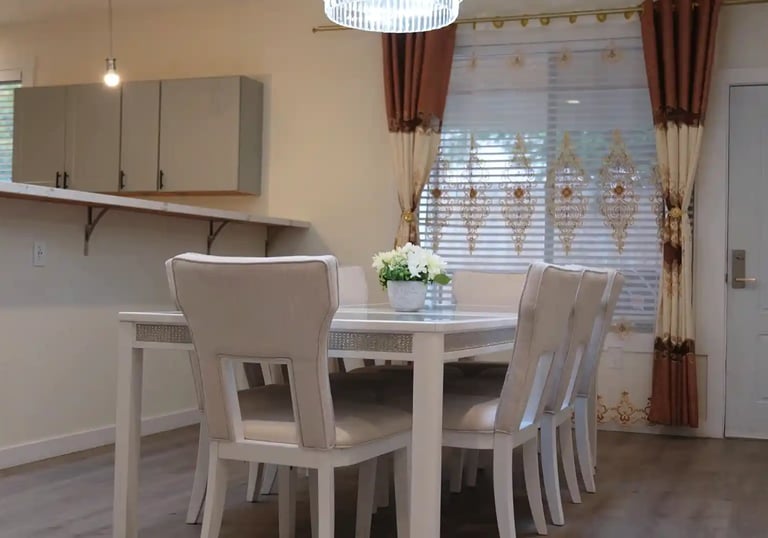 Shared dining room in adult family home with glass table and seating for resident meals.