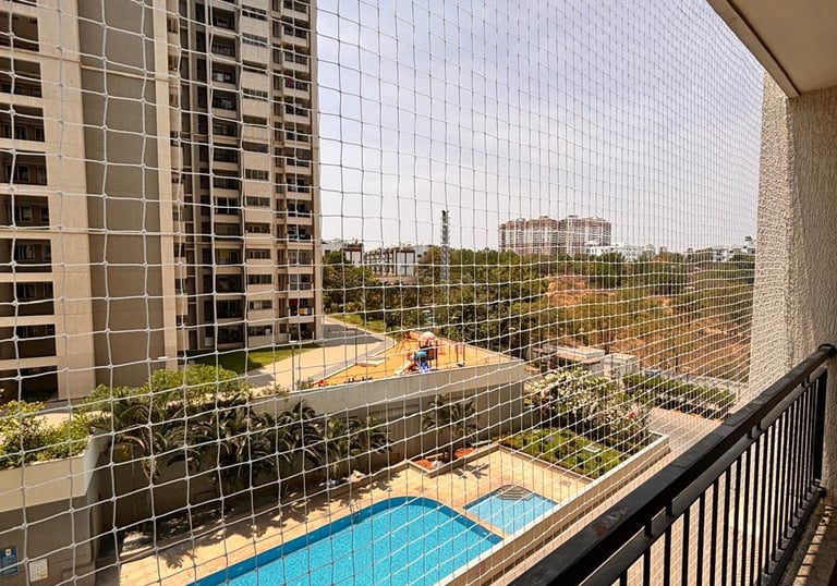 Wide angle shot of a spacious Powai terrace secured with sturdy pigeon safety nets under bright dayl