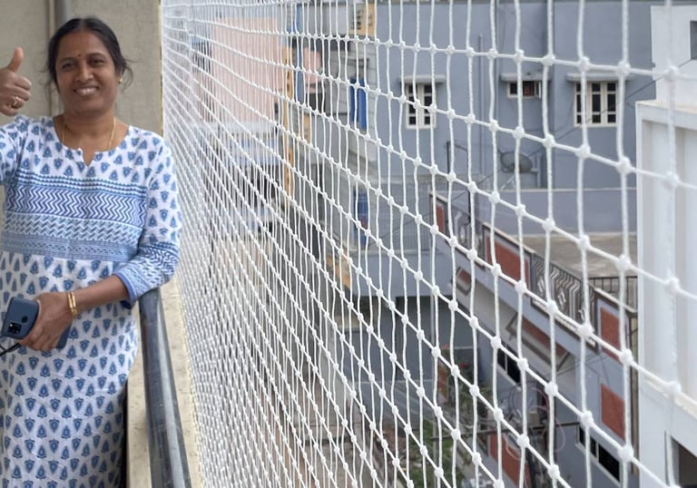 Technician carefully installing a safety net on a residential balcony in Mumbai.