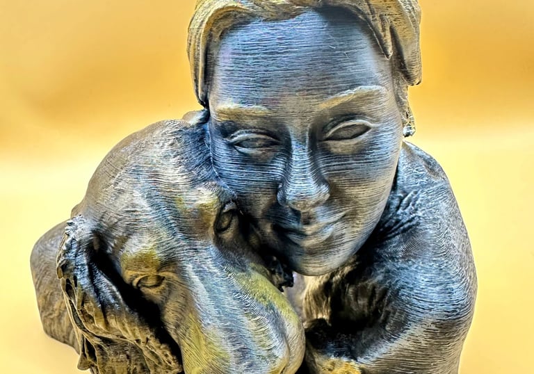 A 3D printed bronze and silver bust featuring a woman hugging her loyal golden retriever dog.