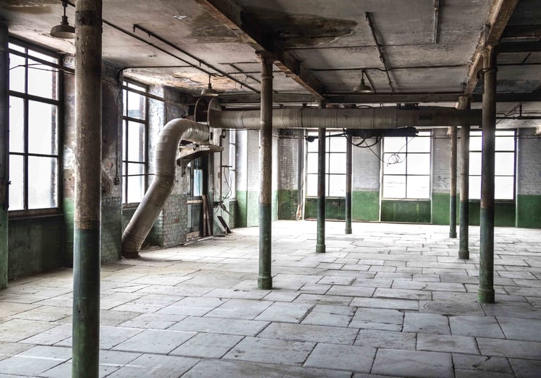 Original stone floor, industrial workings, peeling paints on walls and 6 metre tall windows in the Stone Room at Atlas Studio