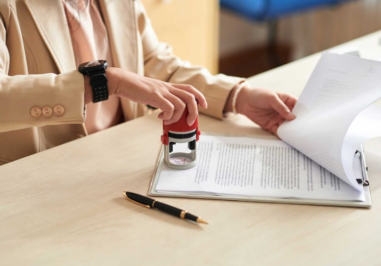 a woman in a suit and a watch on her wrist notarizing a document