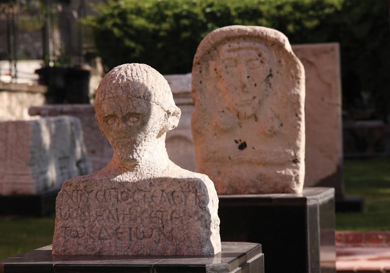 Ancient Roman stone bust and stelae with Greek inscriptions at Amasya museum exhibit.