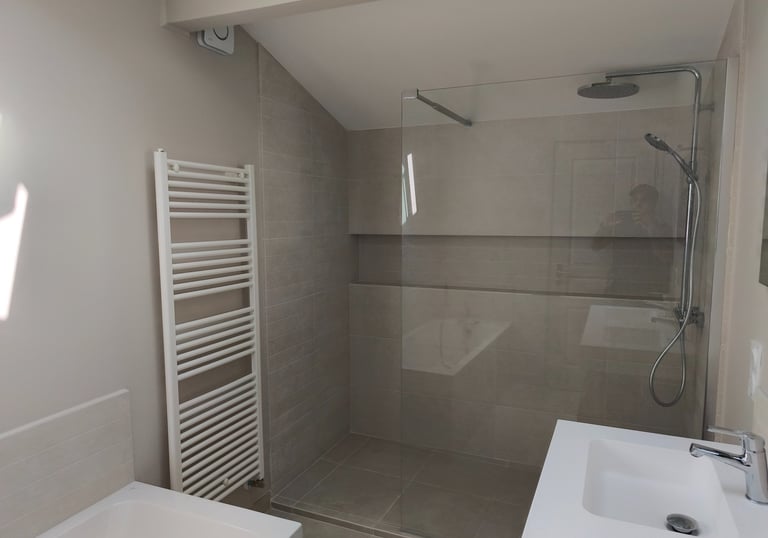 Salle de bain moderne avec douche à l’italienne et baignoire.