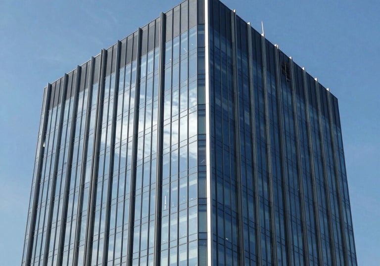 Clean and professional photography of a modern South American commercial office building with glass facade reflecting a clear blue sky, elegant and professional mood.