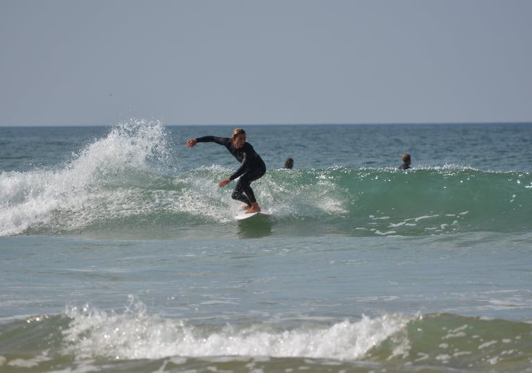 a man in a wetsuit surfing on a wave