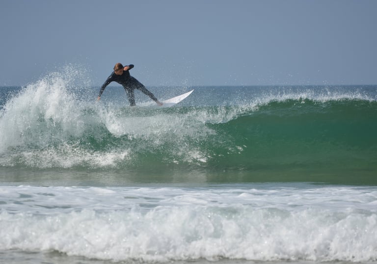 a man in a wetsuit surfing on a wave