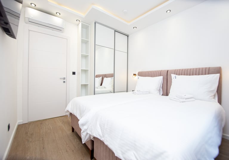 Modern upper floor bedroom with two separable beds and natural light at Villa Aurora Azure