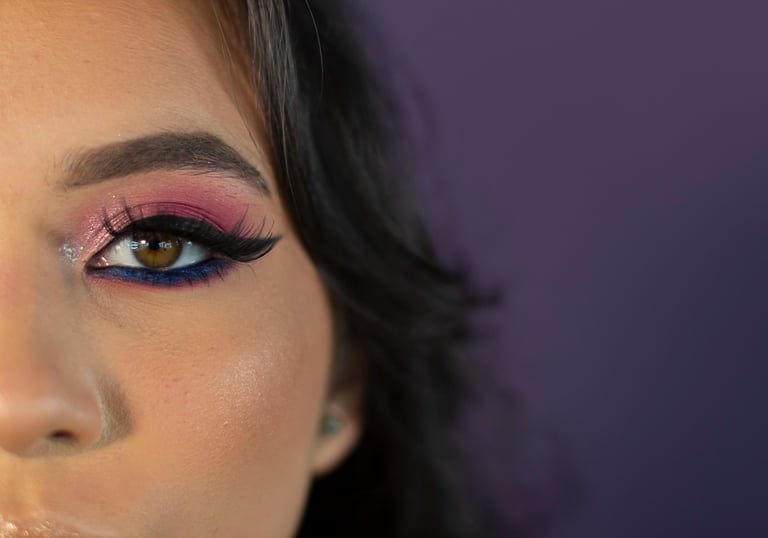 Primer plano del ojo de una mujer con sombra de ojos con brillo rosa y morado, delineador de ojos 
