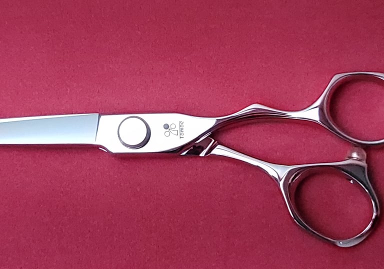 Tijeras de peluquería profesionales Tomoe de acero inoxidable en exhibición, destacando calidad y pr