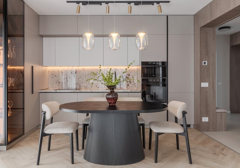 Modern dining room featuring a black round table, stylish chairs, and designer pendant lights in a luxury kitchen.