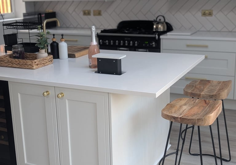 white image, with wooden stools, pink champagne on the countertop, with hidable popout outlets