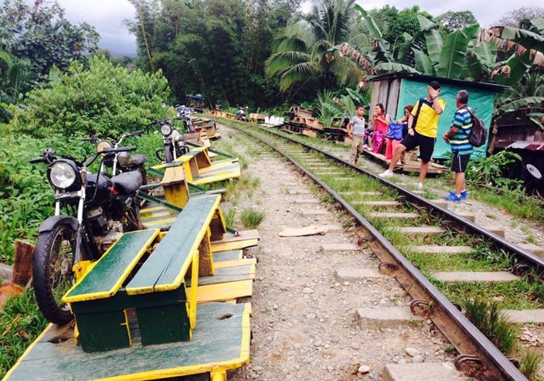 Trolley skates and motorbikes parked along a rural railway track.