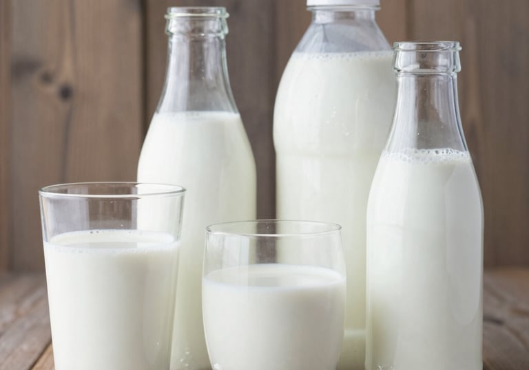 Freshly baked golden loaves of bread and a variety of cakes displayed on a bakery counter.