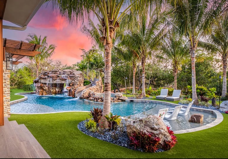 Tropical freeform pool with aqua water, rock grotto and light blue tiling for a vibrant lagoon look.