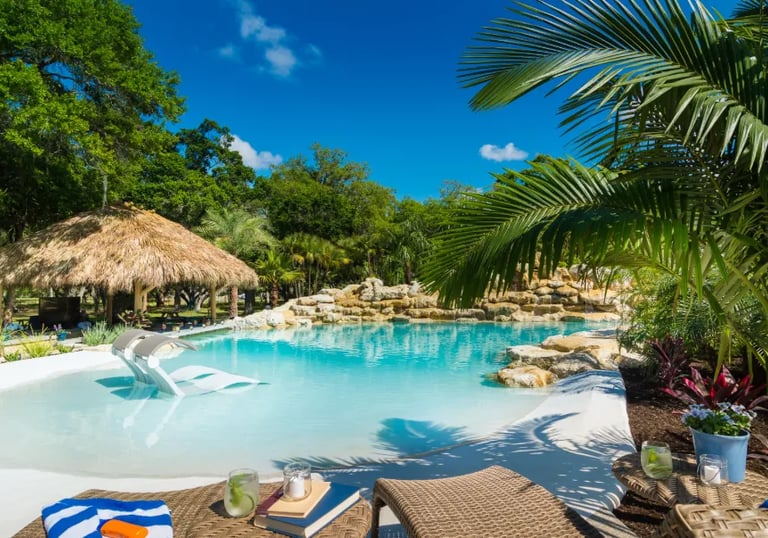  Beach-entry lagoon pool with pale blue water and sand-toned interior creating a tropical, resort-st