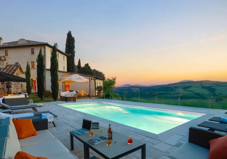 Modern Tuscan-style home with Rectangular pool with pale blue water and light stone tiling