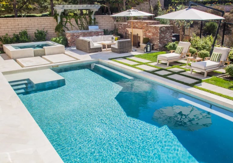 Contemporary pool with turquoise water, glassy mosaic tiling and crisp white concrete surrounds