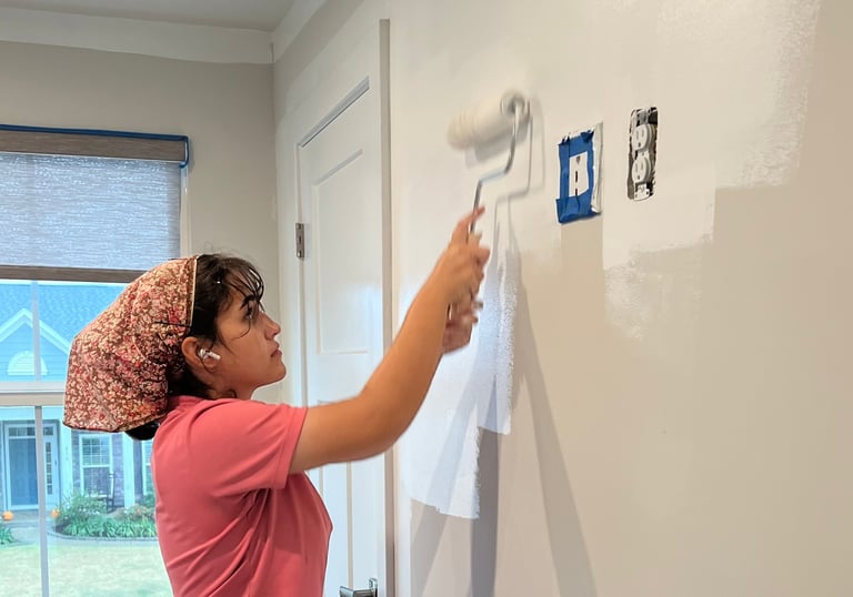 Team member painting a customer's wall white.