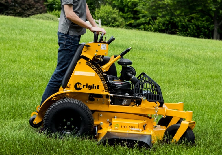 Wright Stander X mower with a team member mowing grass.