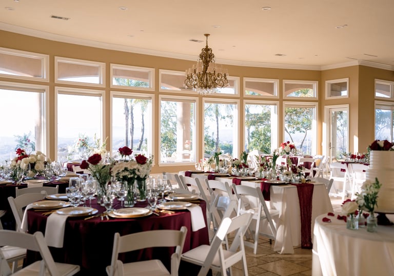 Reception room with red table linens and red and white flowers