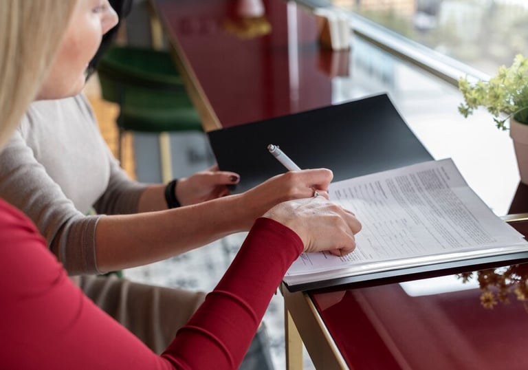 Deux personnes travaillant ensemble sur un document, l'une prenant des notes.