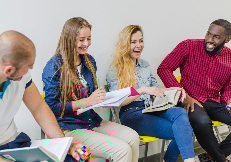 Groupe de personnes discutant et riant lors d'une session de formation.