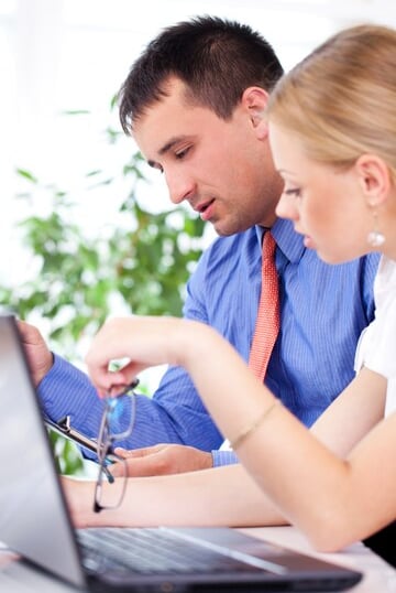 Deux personnes travaillant ensemble sur un ordinateur.